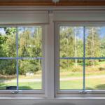 Two windows with view of green meadows and trees.