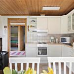 Kitchen with dining area, fireplace, and view into bedroom with bunk bed.