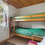 Room with bunk bed, window, and chair.