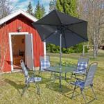Red wooden cabin with patio, table, four chairs, and umbrella.