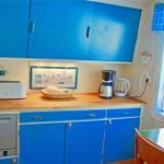 Kitchen with blue cabinets, wooden countertop, and window view