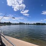 Seeufer mit Wassersportanlage und klarem Himmel.