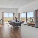 Großes Esszimmer mit Tisch, Stühlen und Blick auf Felder.
