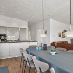 Moderne Küche mit Esstisch und Wohnbereich mit Sofa und Fernseher.