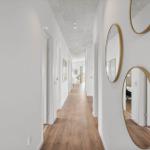 Flur mit Holzboden und runden Spiegeln an der Wand.