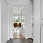 Flur mit Waschmaschine, Tür zum Esszimmer mit Tisch und Stühlen.