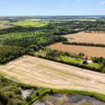 Ein kleines Haus in einer ländlichen Umgebung mit Feldern und Wäldern.