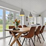 Essbereich mit Holztisch, braunen Stühlen und Blick auf die Terrasse.