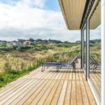 Terrasse mit Liegestühlen und Blick auf die Dünenlandschaft.
