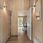 Hausflur mit Holzwand, Garderobe und Blick in Esszimmer.