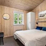 Schlafzimmer mit Holzwand, Bett, Fenster und Schrank.