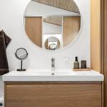 Bad mit Waschbecken, Spiegel und Handtuch.