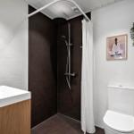 Badezimmer mit Dusche, Toilette und Waschbecken.