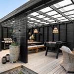 Terrasse mit Grill, Tisch, Stühlen und Fussballtisch unter Dach.