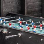 Tischfußballtisch mit roten und blauen Spielern im Freien.