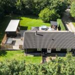 Haus mit Garten, Whirlpool und Terrasse in grüner Umgebung.
