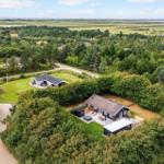Haus mit Terrasse und Grillplatz in grüner Umgebung mit Blick auf die Landschaft.