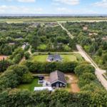 Haus mit Garten und Terrasse in grüner Umgebung mit Blick aufs Meer.