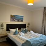 Schlafzimmer mit Bett, Wandbild und Fenster.