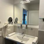 Badezimmer mit Waschbecken, Spiegel und Handtuch