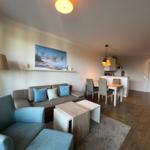 Wohn- und Essbereich mit Sofa, Tisch und Küchenzeile.