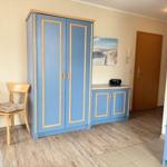 Schlafzimmer mit blauem Schrank und Holzfußboden