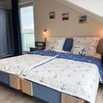 Schlafzimmer mit Bett, Nachttischen und Garderobe unter Dachschrägen