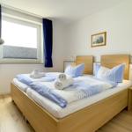 Bedroom with double bed, window, and wooden furniture
