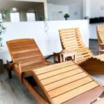 Wooden loungers and plants indoors.