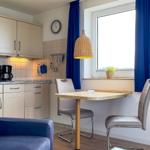 Kitchen with dining area, blue curtains, and window view.