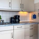Kitchen with countertop, sink, coffee maker, and kitchen utensils.