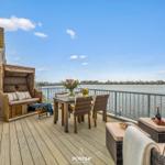 Terrasse mit Sitzgelegenheiten und Blick auf Wasser