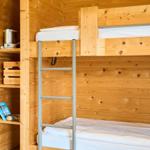 Doppelstockbett mit Kletterleiter und Holzwand im Schlafzimmer