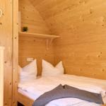 Schlafzimmer mit Holzwand und Bett mit weißen Kissen.
