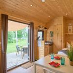 Holzhaus mit Schlafgelegenheit, Küchenzeile und Terrasse mit Gartenblick.