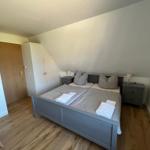 Schlafzimmer mit Doppelbett, zwei Nachttischen und Holzboden.