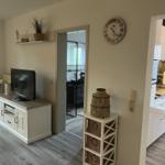 Wohnbereich mit TV, Küche und Badezimmer sichtbar.