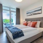 Schlafzimmer mit Doppelbett, Balkon und Wandbild.