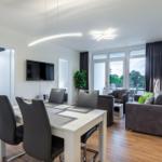 Essbereich mit Tisch und Stühlen, Wohnbereich mit Sofa und Fernseher.