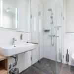 Moderne Badezimmer mit Dusche, Waschbecken und WC.
