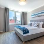 Schlafzimmer mit Doppelbett, Fenster und Wandbild.