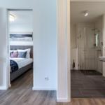 Schlafzimmer mit Bett und Bad mit Dusche und Waschbecken