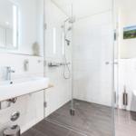 Moderne Badezimmer mit Dusche, Waschbecken und WC.