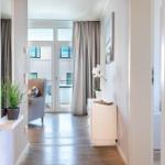 Halle mit Garderobe, Pflanzen und Blick auf Balkon mit Sitzgelegenheit.