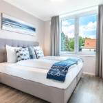 Schlafzimmer mit Bett, Fenster und TV.