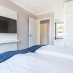 Schlafzimmer mit Bett, TV und Schrank