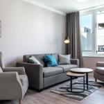 Wohnzimmer mit Sofa, zwei Sesseln und Fensterblick.