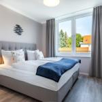 Schlafzimmer mit Bett, Fenster und TV.