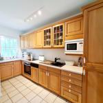 Küche mit Holzschränken, Spüle und Mikrowelle