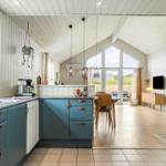 Küche mit blauen Schränken und Essbereich mit Holztisch.